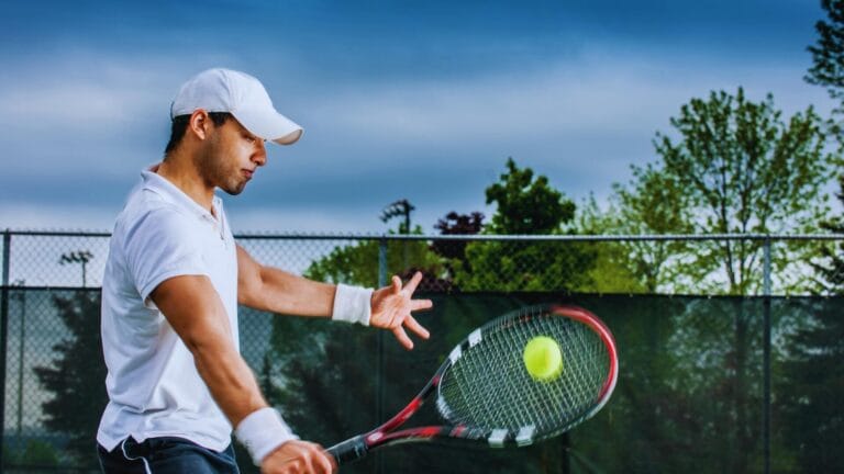 لاعب كورة تنس يستعد لضرب كرة التنس الصفراء على ملعب تنس