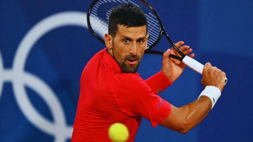 نوفاك ديوكوفيتش لاعب التنس الصربي يشاهد الكرة أثناء ضربته الخلفية في دورة الألعاب الأولمبية ونوفاك أفضل لاعب تنس في التاريخ